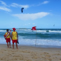 LIfeguards with red flag and sky surfers